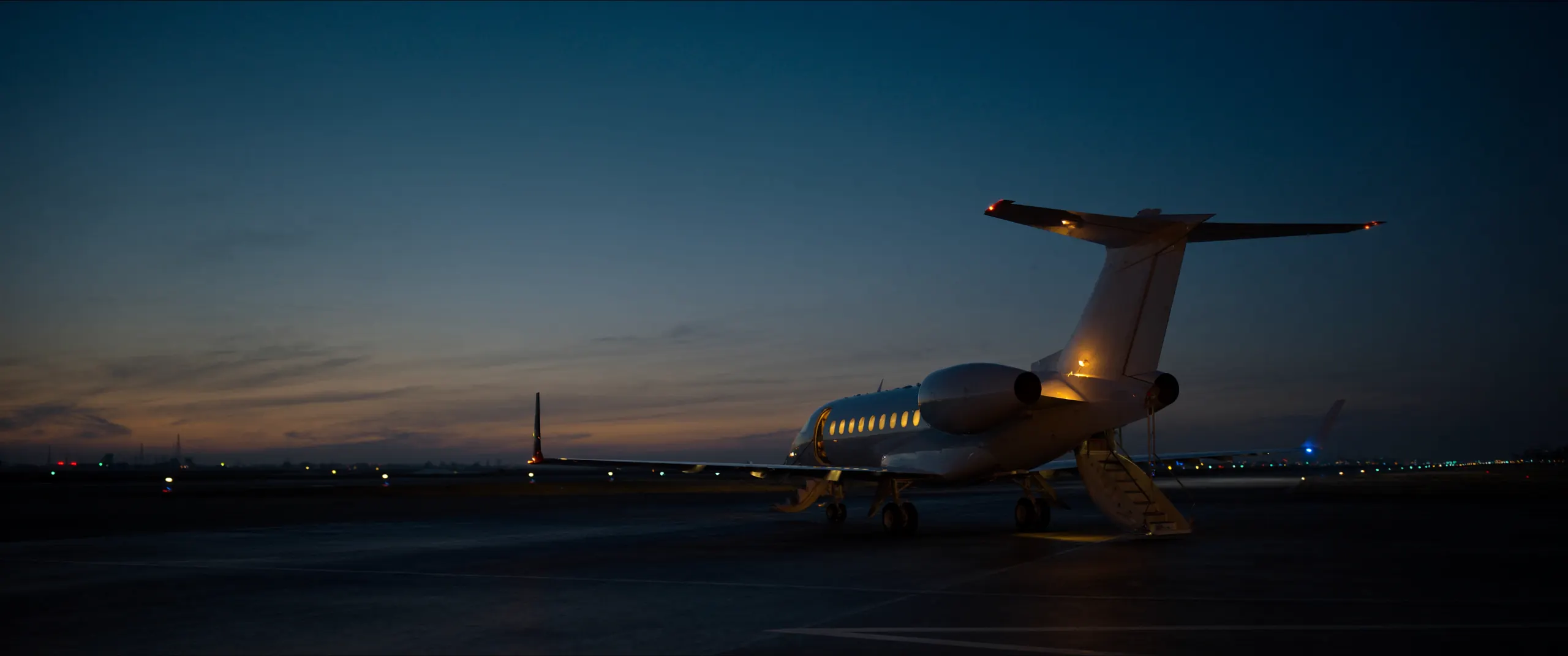 An apron at dusk with ground service equipment